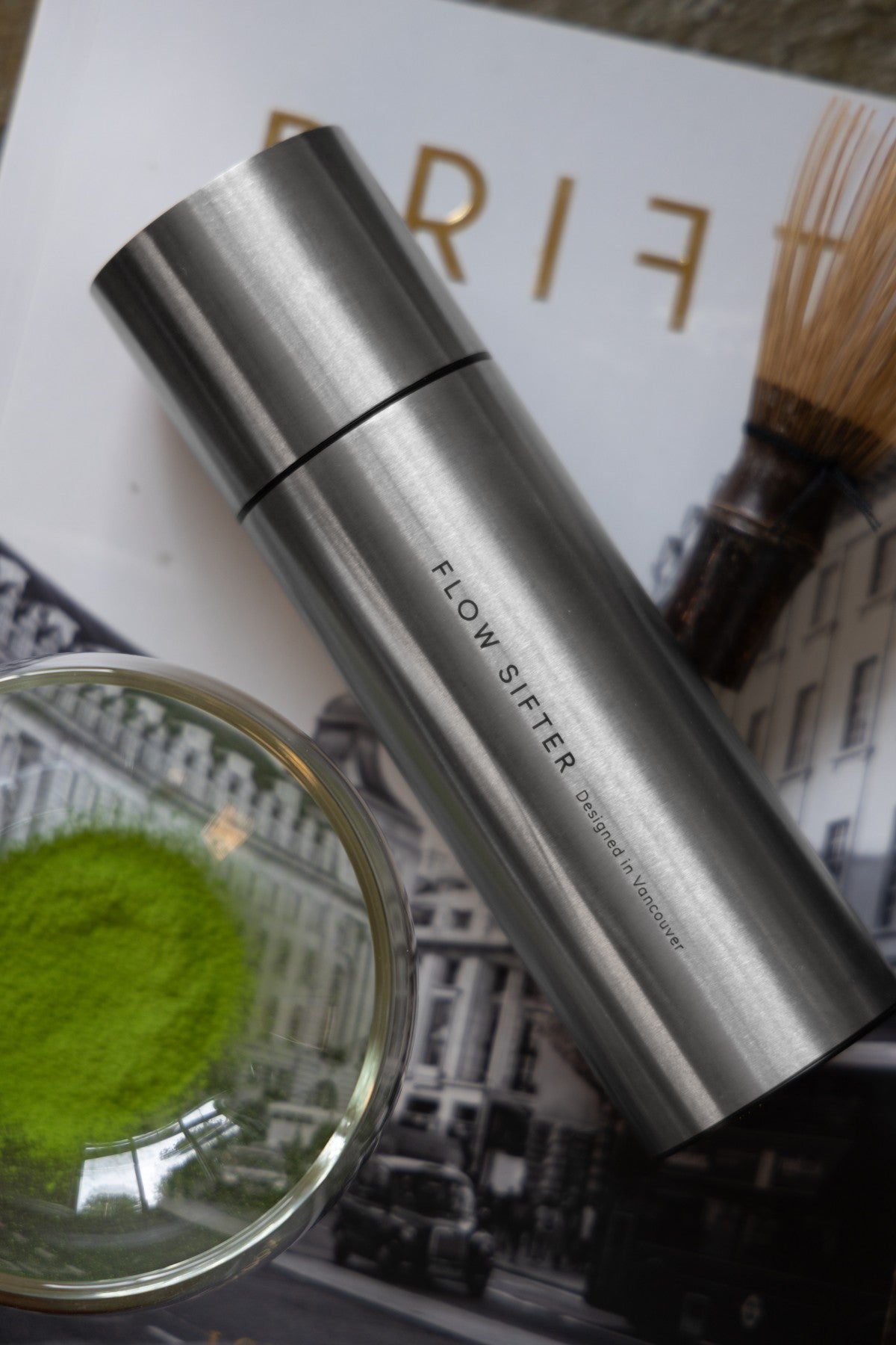 Brushed Flow Sifter photographed at an angle beside matcha and a whisk