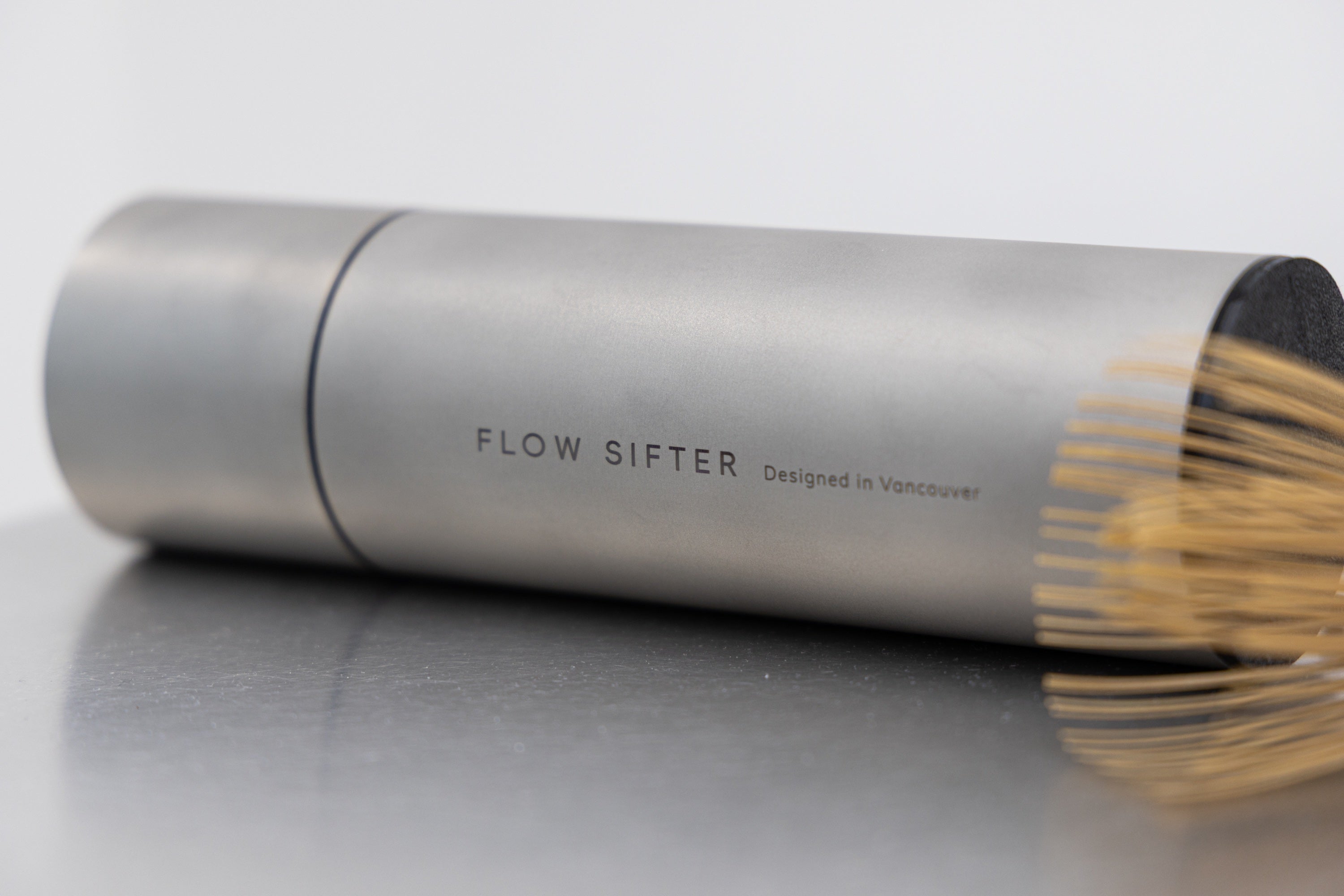 Matte stainless steel Flow Sifter beside a bamboo matcha whisk